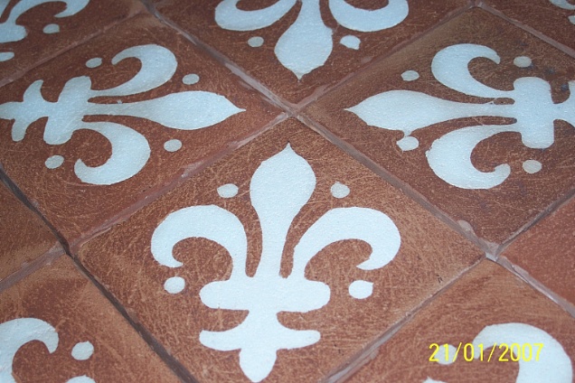 Pavimenti in cotto artistico con giglio realizzato con argilla bianca.